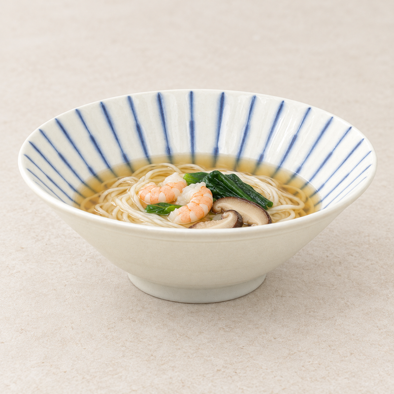Pale beige and blue-striped bowl with noodles, broth, shrimp, mushrooms and green vegetables.