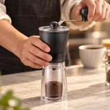 HARIO MSS-1DTB slim coffee mill held while turning its hand crank