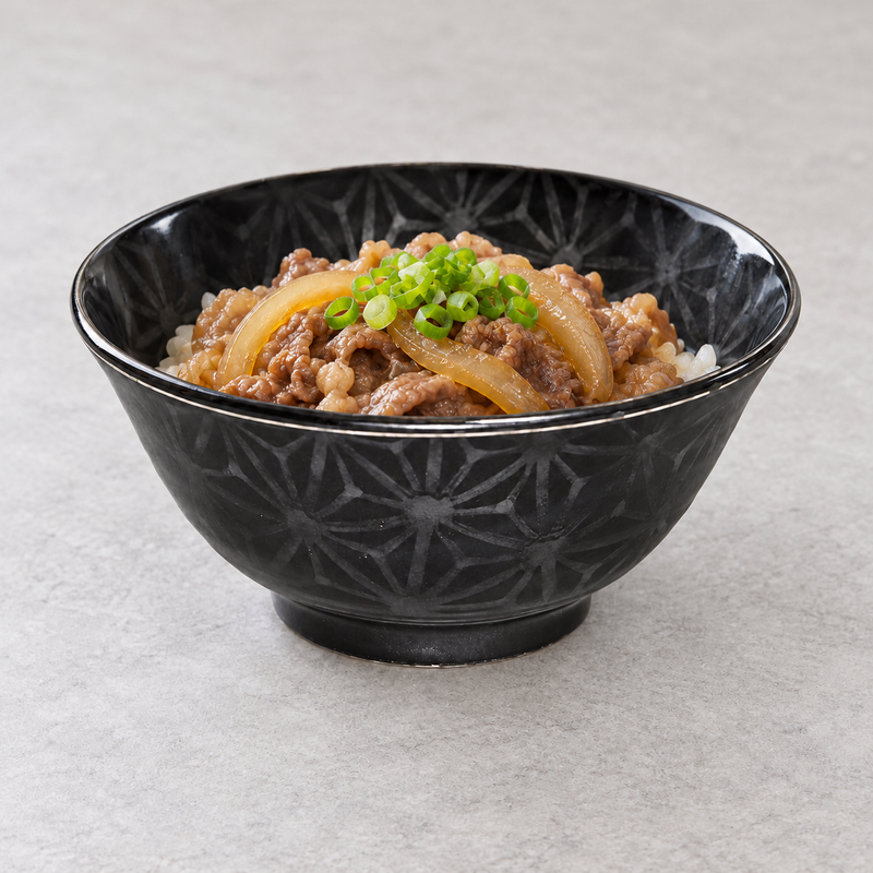 Black geometric ceramic bowl with rice, sliced meat, onion and scallions.