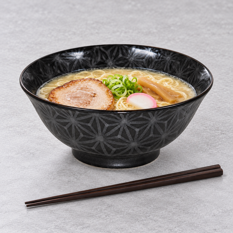 MY578-GAL bowl with noodles in pale broth, a rolled browned meat slice, scallions, tan strips and a pink-edged white slice; chopsticks lie in front.