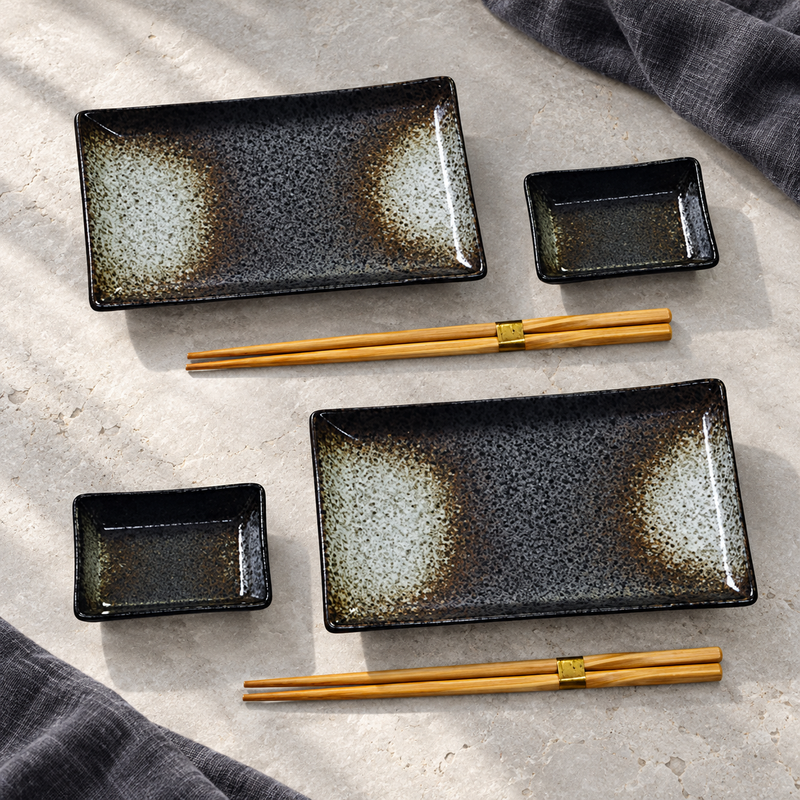 Black mottled sushi set with two plates, two dishes and two pairs of chopsticks