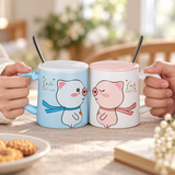 PC27-1 blue and pink pig mugs held by their outside handles with front artwork visible
