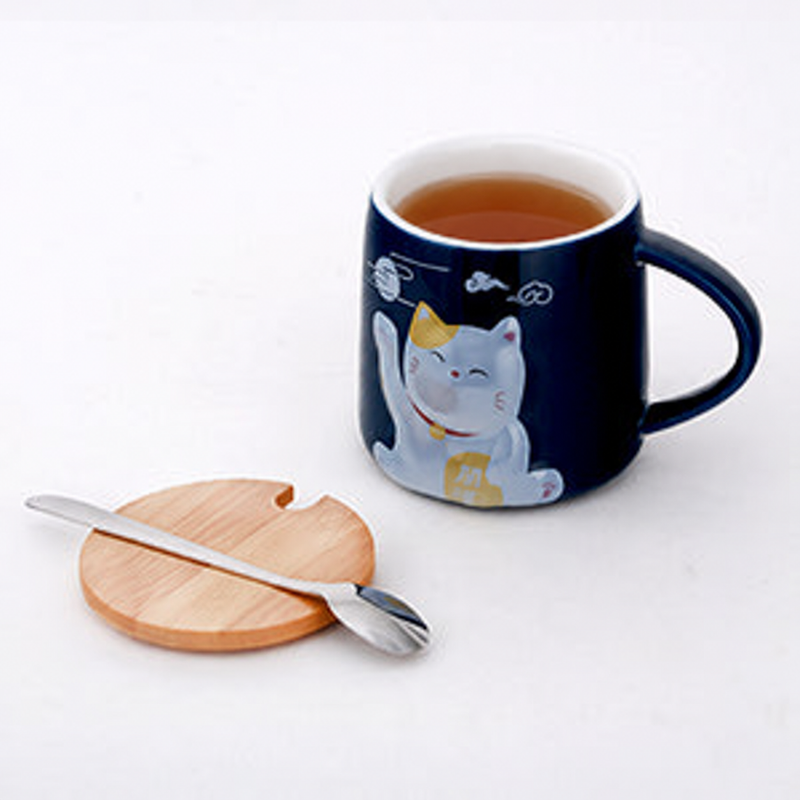 PC37-4 lucky-cat mug with amber tea, beside the pictured wooden piece and spoon