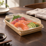 PH-09 kraft sushi tray with clear lid holding sashimi on a dark wood dining table
