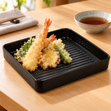 Glossy black square ridged-base melamine plate serving shrimp and vegetable tempura