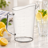 Empty PMU-200 measuring cup beside separate citrus reamer, lemons, pitcher and glasses