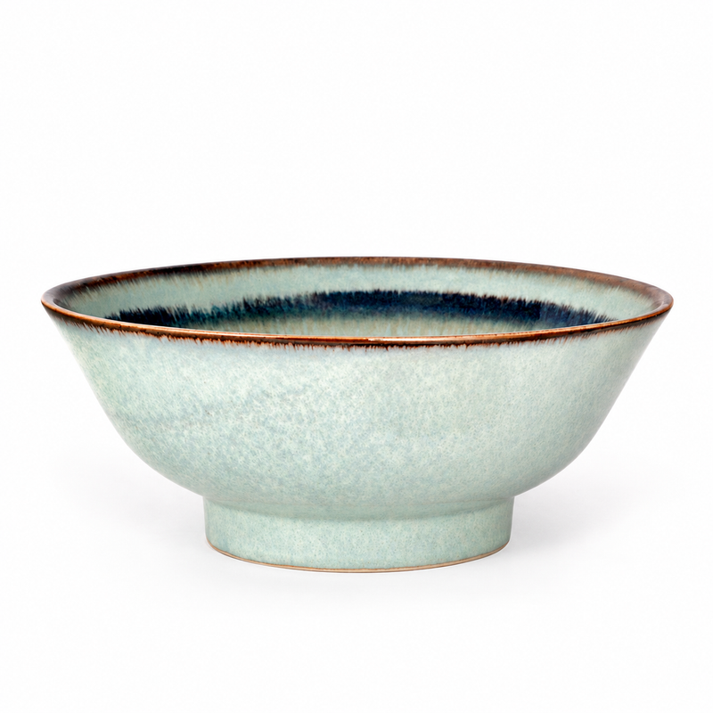 Empty PZ0068 ceramic bowl in a low oblique view with a pale mint-gray mottled exterior, brown rim, dark inner band and short ring foot.