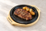 Round Iron Sizzling Steak Plate with Wood Base, 9.25". Serving suggestion.