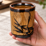 RT70-11 brown bamboo teacup held with amber tea