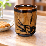 RT70-11 brown bamboo teacup with tea beside a separate biscuit dish