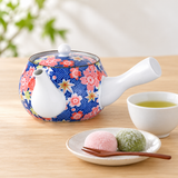 SN7-YBL closed floral teapot beside a separate cup of tea and a plate of mochi.