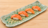 Pooled green rectangular ceramic platter with a modest sushi serving
