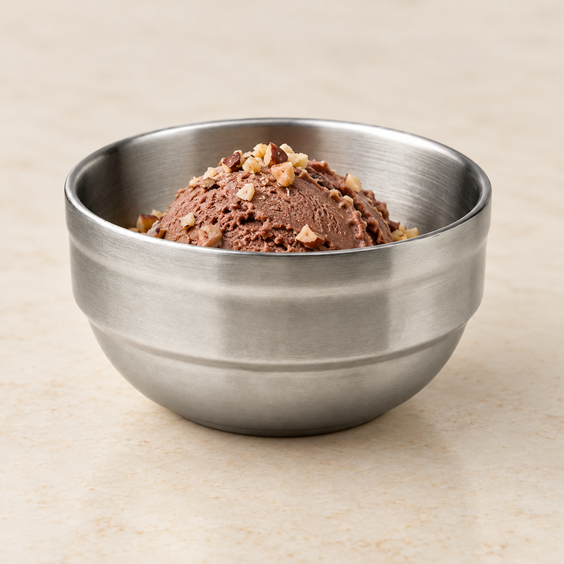 Stainless steel dessert bowl holding chocolate ice cream and chopped nuts.