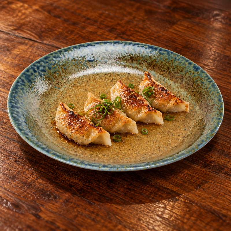 Gyoza on the green-blue and gold-brown 9½-inch porcelain plate