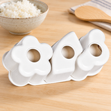 White three-shape 151381 sushi mold beside a rice bowl and paddle
