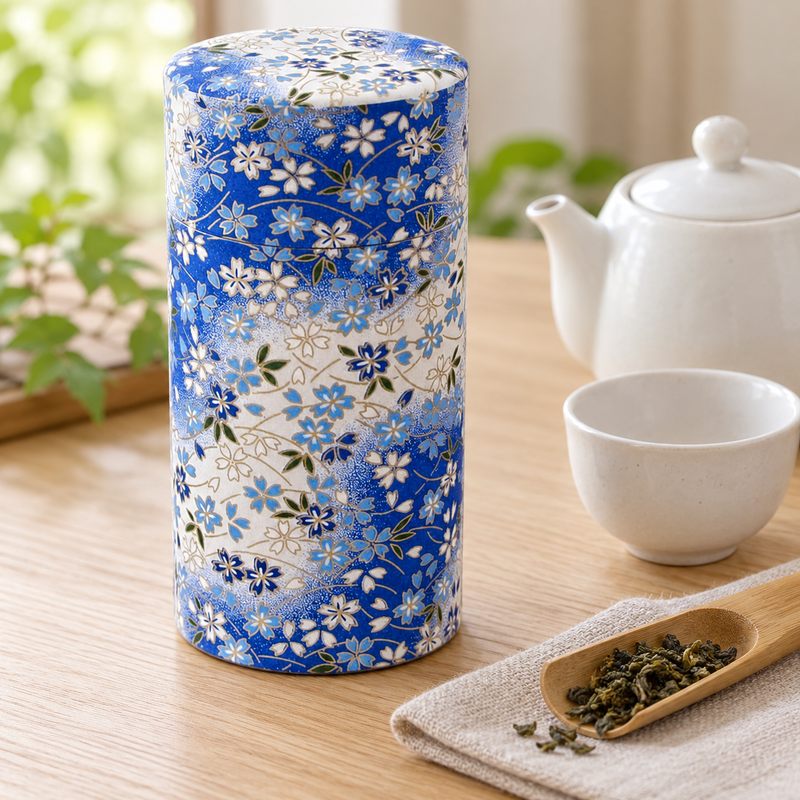 Closed TCY518 tea canister beside a separate white teapot, cup and scoop of loose tea