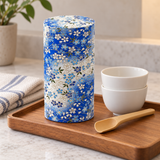 Closed TCY518 tea canister on a separate tray with stacked cups and an empty bamboo scoop