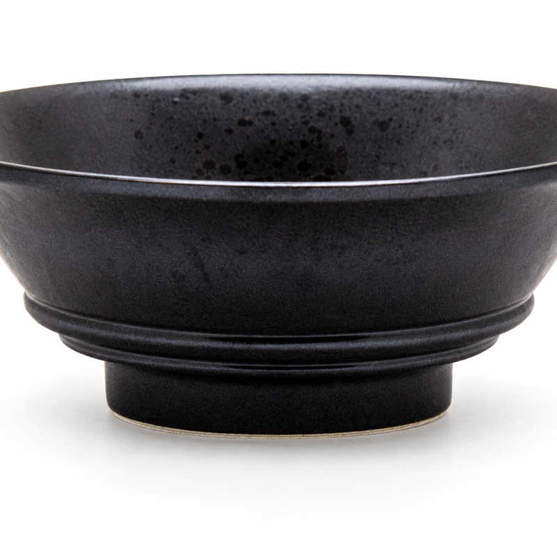 Close view of the black bowl side, lower bands and circular foot