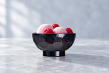 Black bowl with mochi and raspberries