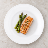 White round ceramic plate with salmon and asparagus