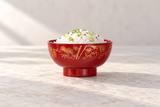 Red and gold bowl with rice and scallion