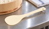 YE-109 ivory rice spatula with hanging cord on a restaurant prep counter
