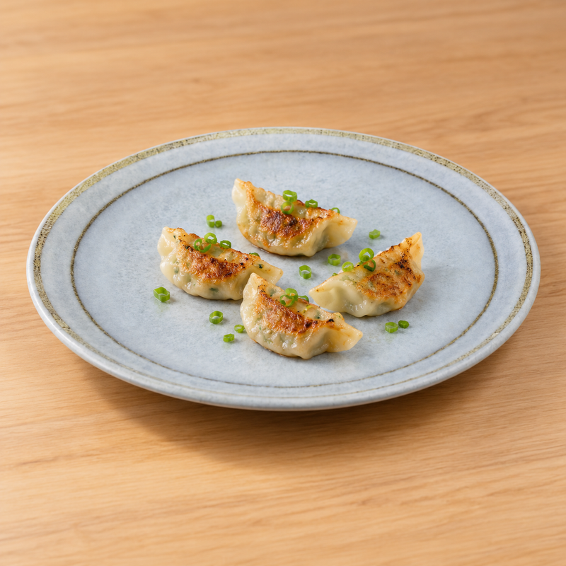YG-7612BS round plate with four gyoza on a wood table