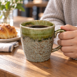 YT72-1 olive-green and mottled ceramic mug held by its handle with coffee