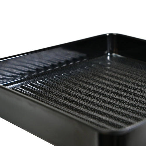 Close view of the black plate's parallel ridges, finely textured base and smooth raised sides