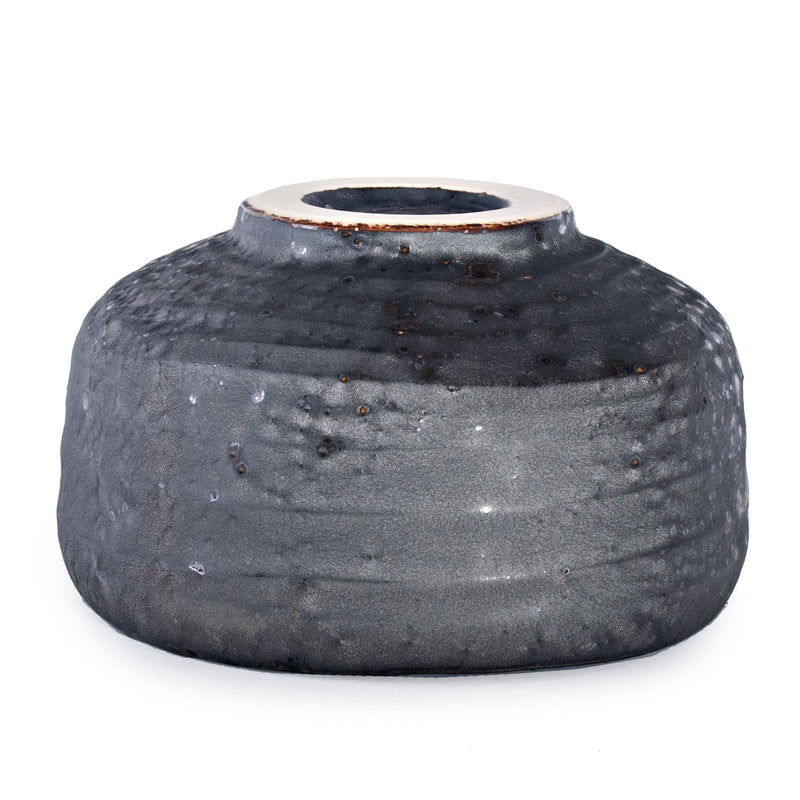 Inverted charcoal matcha bowl showing its circular foot, pale foot edge and banded exterior.
