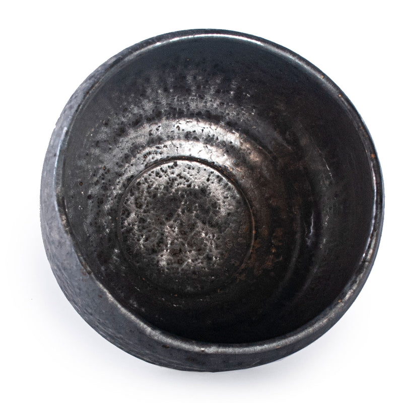 Open interior of the charcoal matcha bowl, showing a rounded basin, horizontal bands and silvery areas.