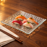 GF6-C clear rippled glass plate with nigiri in a warm tabletop setting