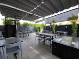 Gray open-back plastic restaurant chair; restaurant setting, other furniture illustrative