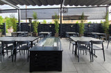 Gray open-back plastic restaurant chair; restaurant setting, other furniture illustrative