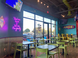 Green open-back plastic restaurant chair; restaurant setting, other furniture illustrative
