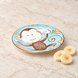 Blue monkey-pattern plate beside banana slices
