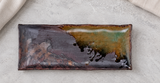 IM211-IK brown and green rectangular plate on a stone table