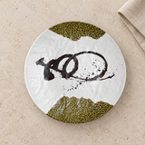 Top view of white melamine round plate with olive accents on stone