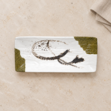 Top view of white melamine footed rectangular plate with olive accents on stone