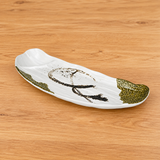 White half-round divided melamine plate with olive accents on a tabletop
