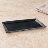 Black rectangular melamine plate with wide rim on stone