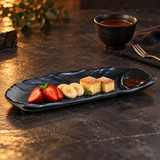 IT-Y3111B textured black oblong melamine plate with fruit, cake and chocolate dipping sauce in its end well