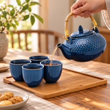 Blue textured tea set with four cups and tray during tea pouring
