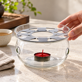 JQW-5N glass tea warmer being positioned before use; candle and cup are styling props, not included