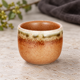 JX8-7 orange-brown sake cup on a stone table; one cup shown
