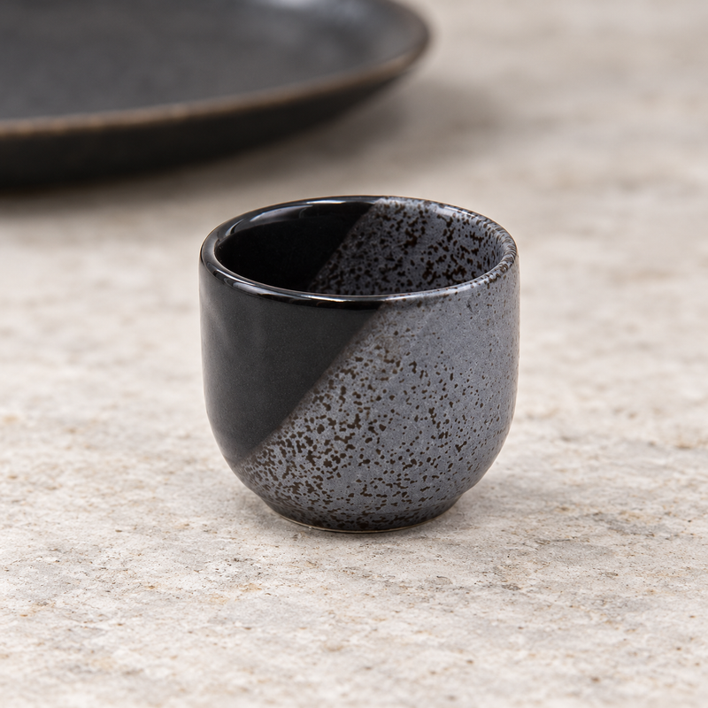 KY8-NW sake cup on a stone tabletop with its diagonal contrasting finish visible