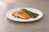 White round melamine plate with salmon and asparagus