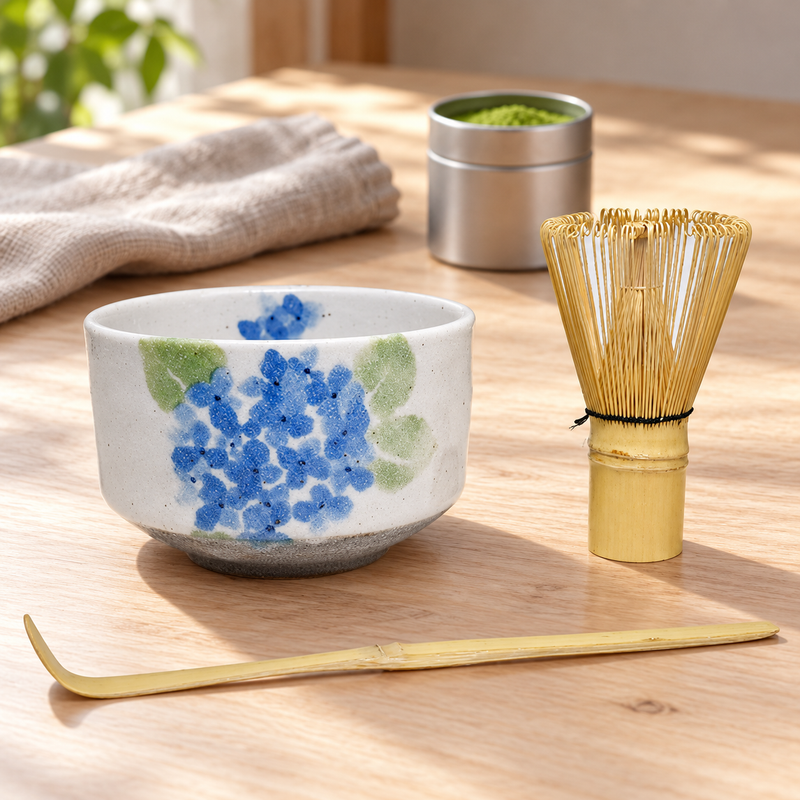 K537S-AJ blue-flower bowl with its bamboo whisk and scoop beside a separate matcha tin