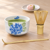 K537S-AJ bowl holding matcha with included whisk and scoop beside a separate sweet