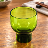 MF24-G green glass sake cup on a wooden table